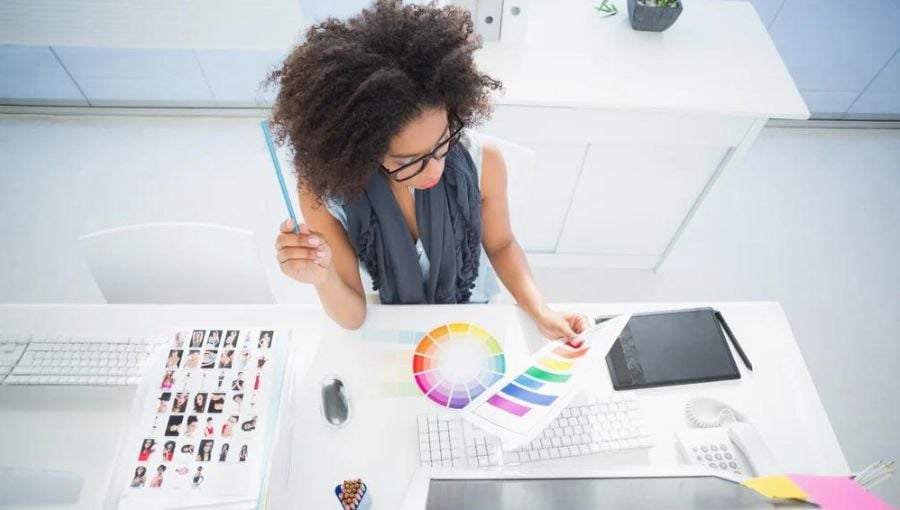 10 best design feedback tools for agencies & in-house design teams - woman with curly hair dwelling on color pallete by her desk