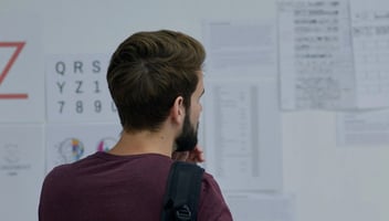 Business marketing team member comparing proofs in a whiteboard