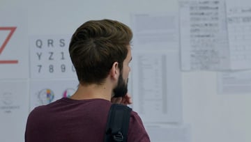 Business marketing team member comparing proofs in a whiteboard