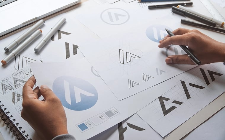 Creative designer reviewing brand guidelines and logos on a desk