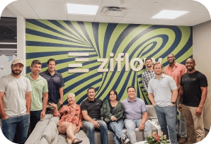 Dallas office team standing in front of Ziflow logo