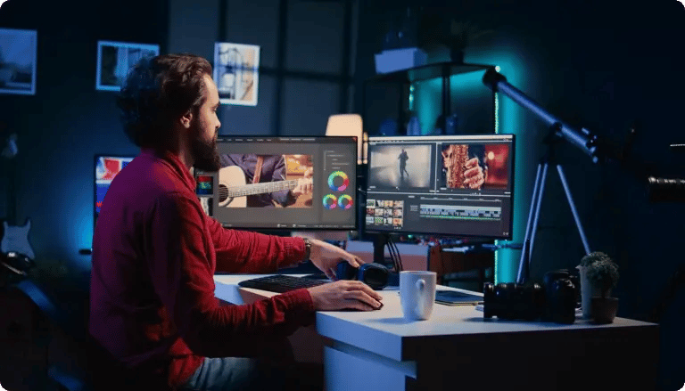 Video editor working on a multi-screen editing setup
