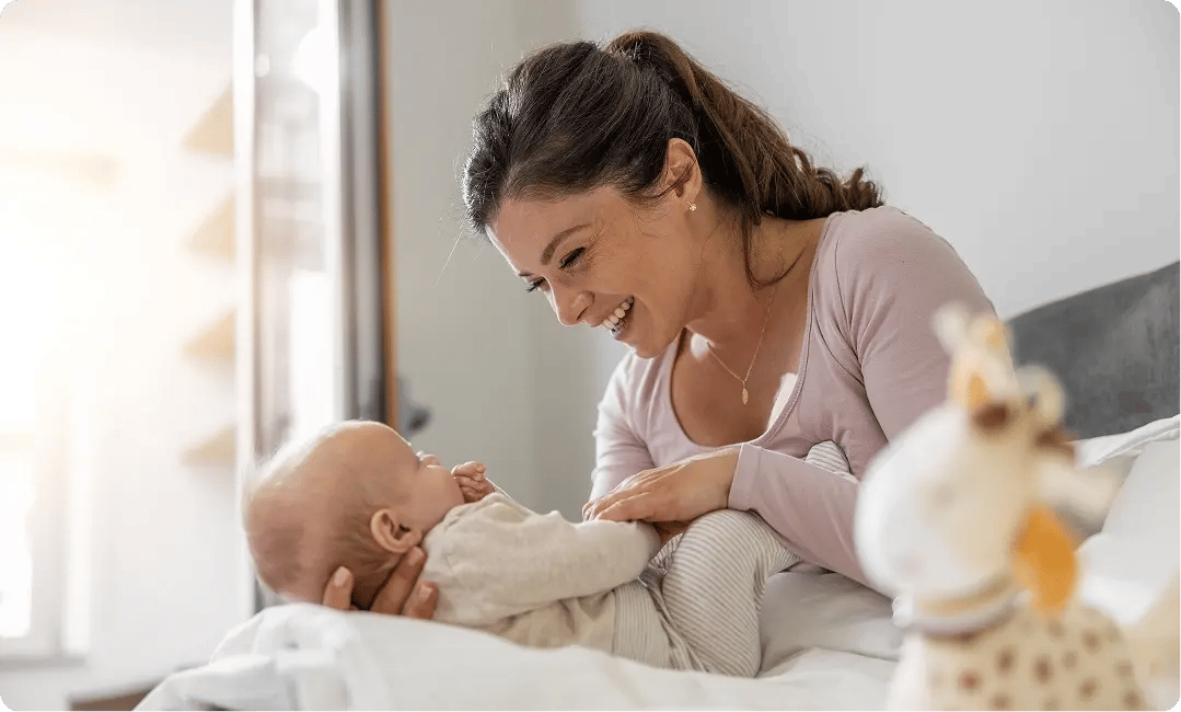 Mother playing with her baby at home