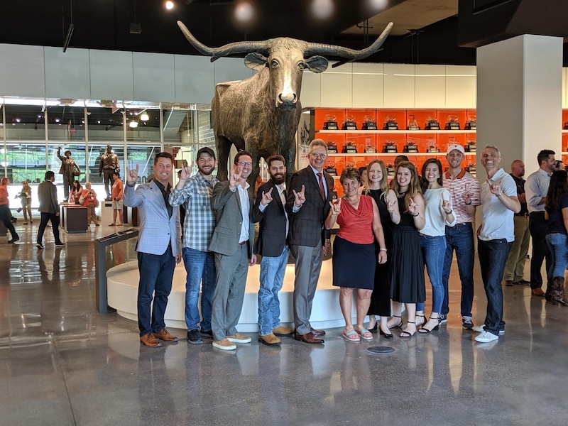 Advent company team posing in The University of Texas Athletics Hall of Fame