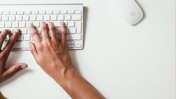 How we launched Proof briefs to improve the quality of creative feedback - man typing on a white keyboard