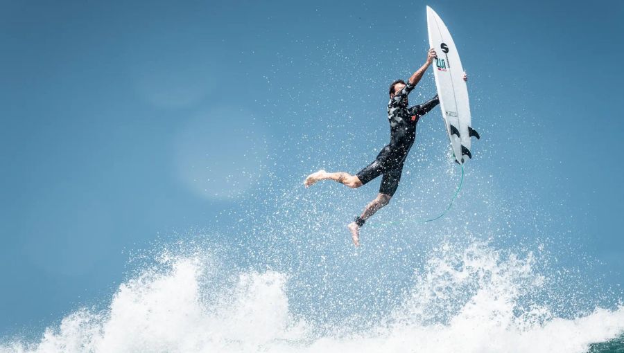 Surfer jumping from a sea waves on his board in the air