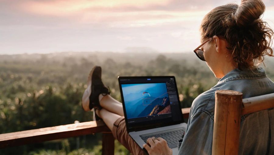 woman working on a laptop by the beautiful background nature on her balcony